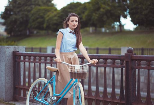 Young beautiful, elegantly dressed woman with bicycle. Beauty, fashion and lifestyle