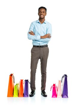 Happy african american man with shopping bags on white background. Holidays concept