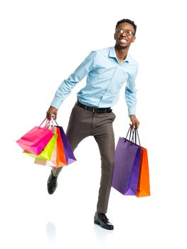 Happy african american man holding shopping bags on white background. Holidays concept