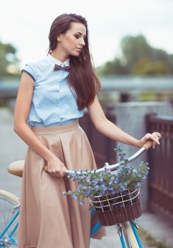 Young beautiful, elegantly dressed woman with bicycle. Beauty, fashion and lifestyle