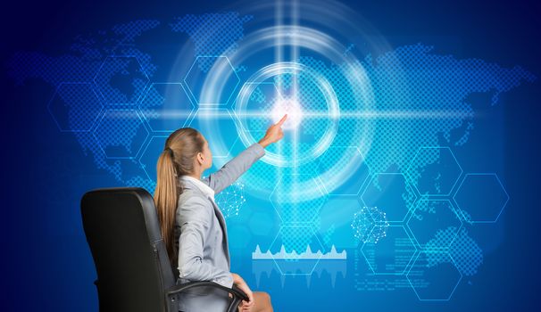 Businesswoman using virtual interface with world map, graphs and other elements, on blue background