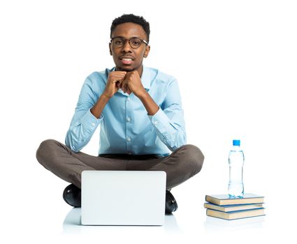 Happy african american college student sitting with laptop on white background