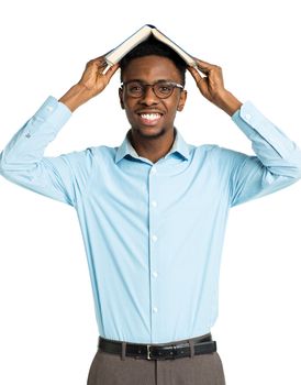 Happy african american college student standing with book on his head on white background