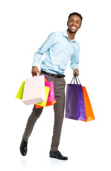 Happy african american man holding shopping bags on white background. Holidays concept