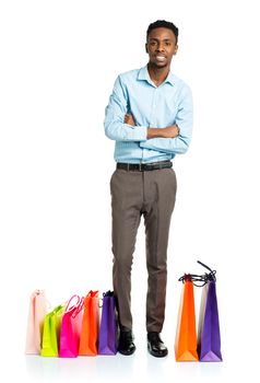 Happy african american man with shopping bags on white background. Holidays concept