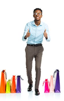 Happy african american man with fingers up and shopping bags on white background. Holidays concept