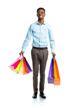 Happy african american man holding shopping bags on white background. Holidays concept