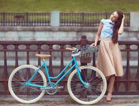 Young beautiful, elegantly dressed woman with bicycle. Beauty, fashion and lifestyle