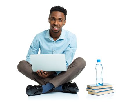 Happy african american college student sitting with laptop on white background