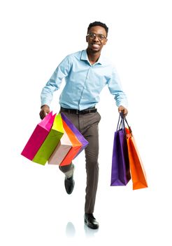 Happy african american man holding shopping bags on white background. Holidays concept