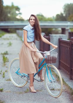 Young beautiful, elegantly dressed woman with bicycle. Beauty, fashion and lifestyle