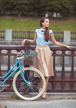 Young beautiful, elegantly dressed woman with bicycle. Beauty, fashion and lifestyle