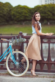 Young beautiful, elegantly dressed woman with bicycle. Beauty, fashion and lifestyle