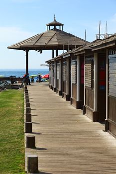 IQUIQUE, CHILE - JANUARY 23, 2015: Wooden sidewalk beside cabins leading to a wooden pavilion on Cavancha beach on January 23, 2015 in Iquique, Chile. Iquique is a free port city in Northern Chile.