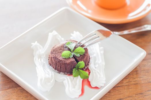 Chocolate lava on white plate and coffee cup, stock photo