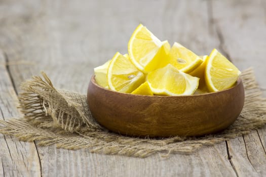 fresh lemons in a bowl on wooden background