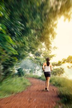 Happy indian beautiful girl on morning walk and exercise or jogging in natural park