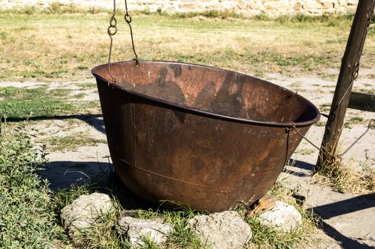 a huge, old, rusty cauldron in the meadow