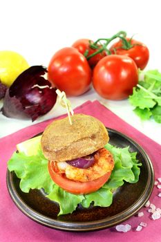 Shrimp burger with tomato, red onion and lettuce