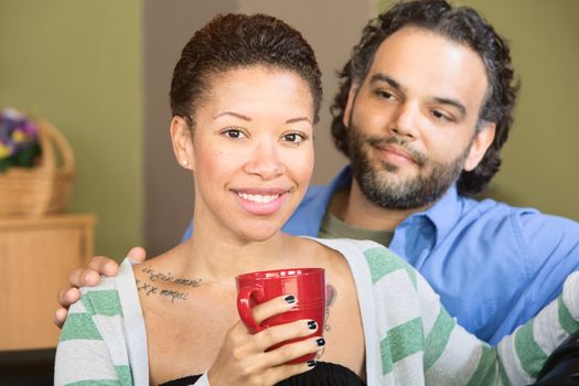 Smiling Hispanic and African couple with drink mug