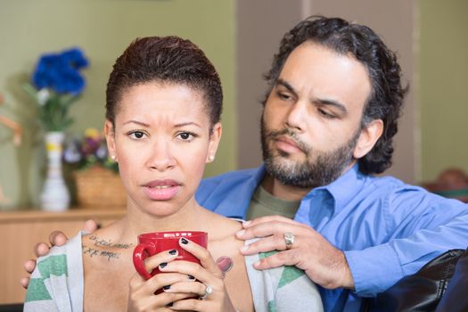 Concerned man with anxious Black woman holding mug