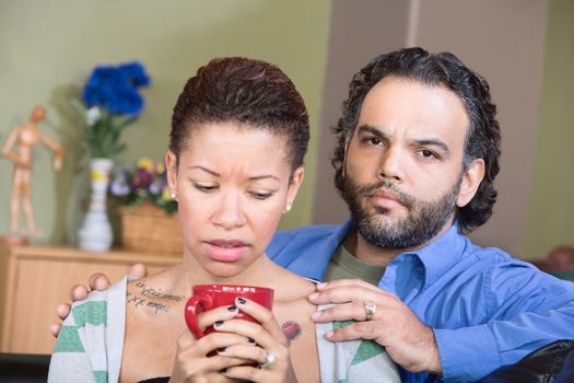 Close up of worried couple sitting together