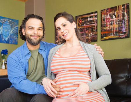 Handsome man with beautiful pregnant woman sitting together