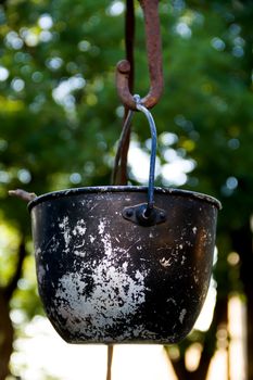 a huge, old, rusty cauldron in the meadow