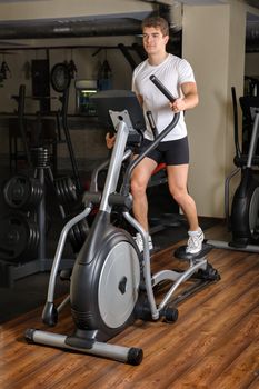 Man Working Out On Elliptical Machine in Gym