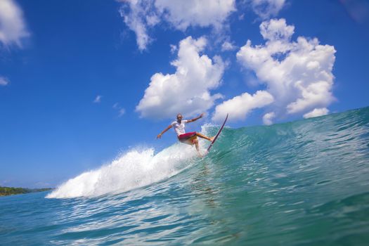 Surfer on Amazing Blue Wave, Bali island.