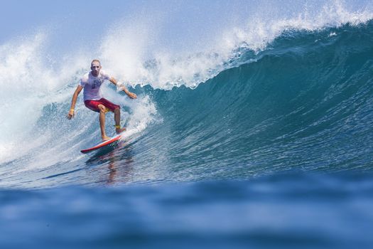 Surfer on Amazing Blue Wave, Bali island.