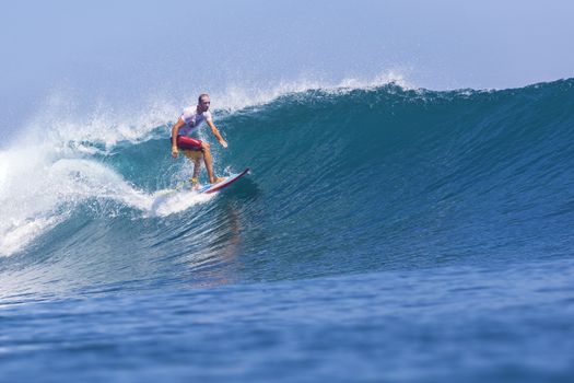 Surfer on Amazing Blue Wave, Bali island.