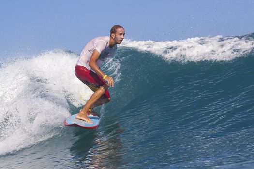 Surfer on Amazing Blue Wave, Bali island.