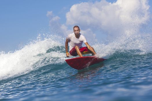 Surfer on Amazing Blue Wave, Bali island.