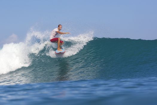 Surfer on Amazing Blue Wave, Bali island.