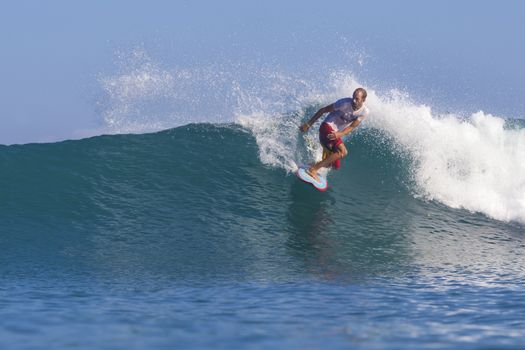 Surfer on Amazing Blue Wave, Bali island.