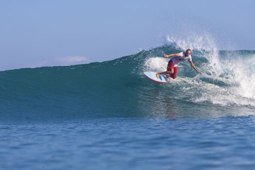 Surfer on Amazing Blue Wave, Bali island.