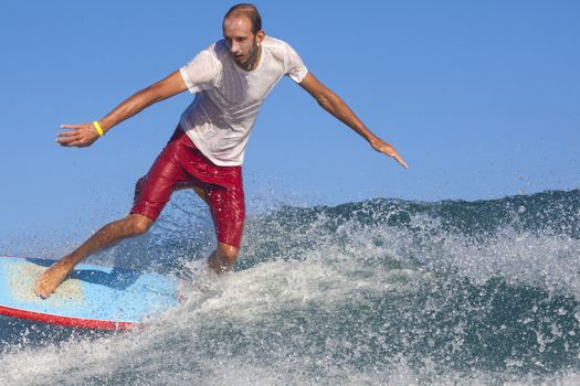 Surfer on Amazing Blue Wave, Bali island.