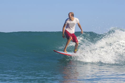 Surfer on Amazing Blue Wave, Bali island.