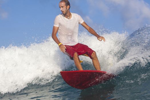 Surfer on Amazing Blue Wave, Bali island.