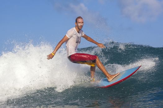 Surfer on Amazing Blue Wave, Bali island.