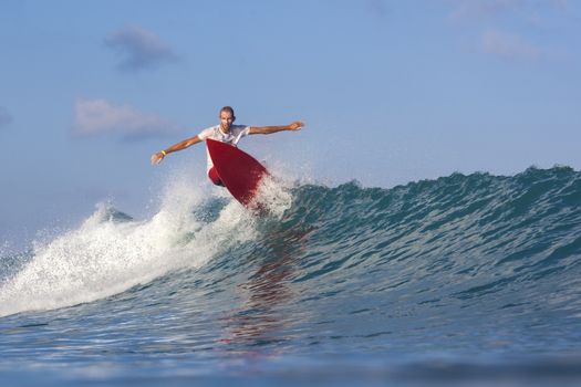 Surfer on Amazing Blue Wave, Bali island.