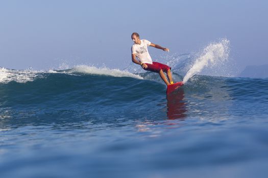 Surfer on Amazing Blue Wave, Bali island.