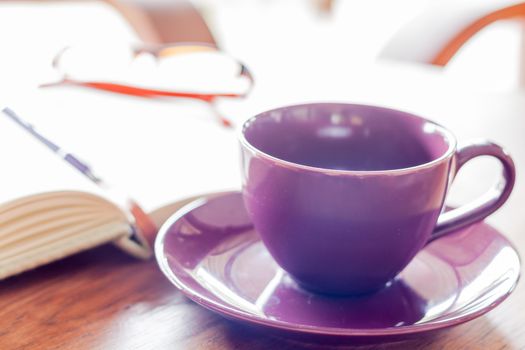 Purple coffee cup on wooden table, stock photo