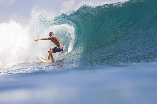 Surfer on Amazing Blue Wave, Bali island.