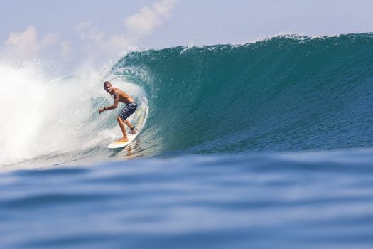 Surfer on Amazing Blue Wave, Bali island.