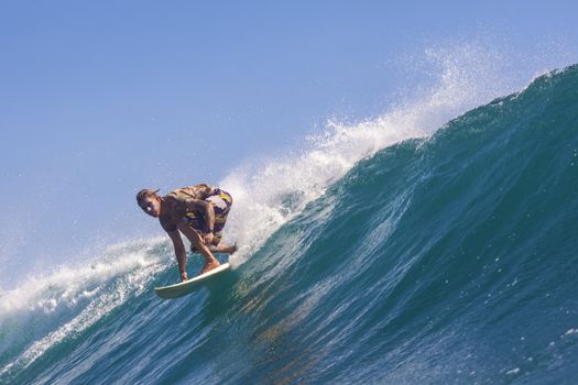 Surfer on Amazing Blue Wave, Bali island.