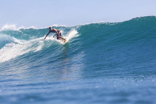 Surfer on Amazing Blue Wave, Bali island.