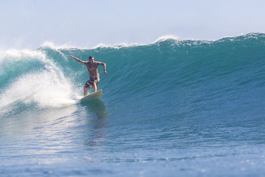 Surfer on Amazing Blue Wave, Bali island.