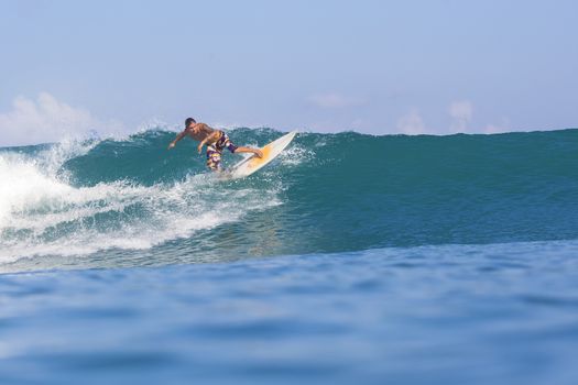 Surfer on Amazing Blue Wave, Bali island.